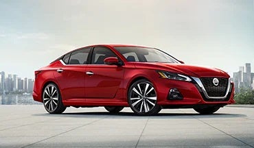 2023 Nissan Altima in red with city in background illustrating last year's 2022 model in Fairbanks Nissan in Fairbanks AK